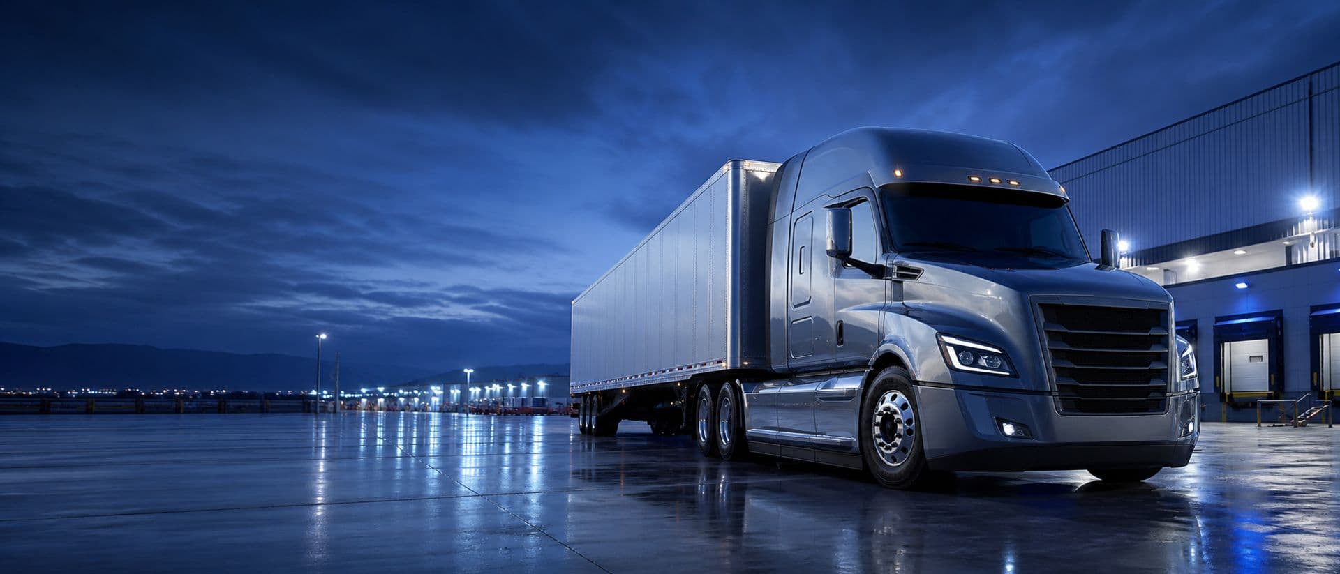 Tractocamión premium en terminal logística al atardecer